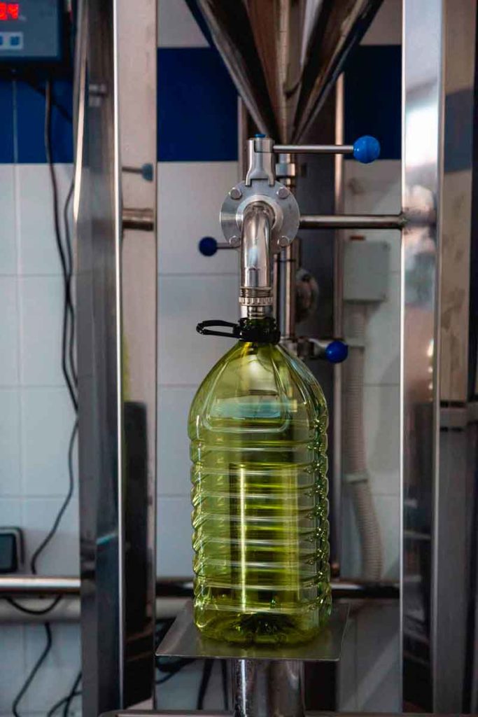 Botella de plástico antes de ser envasado el aceite de oliva, en el molino de la maquila para autoconsumo.